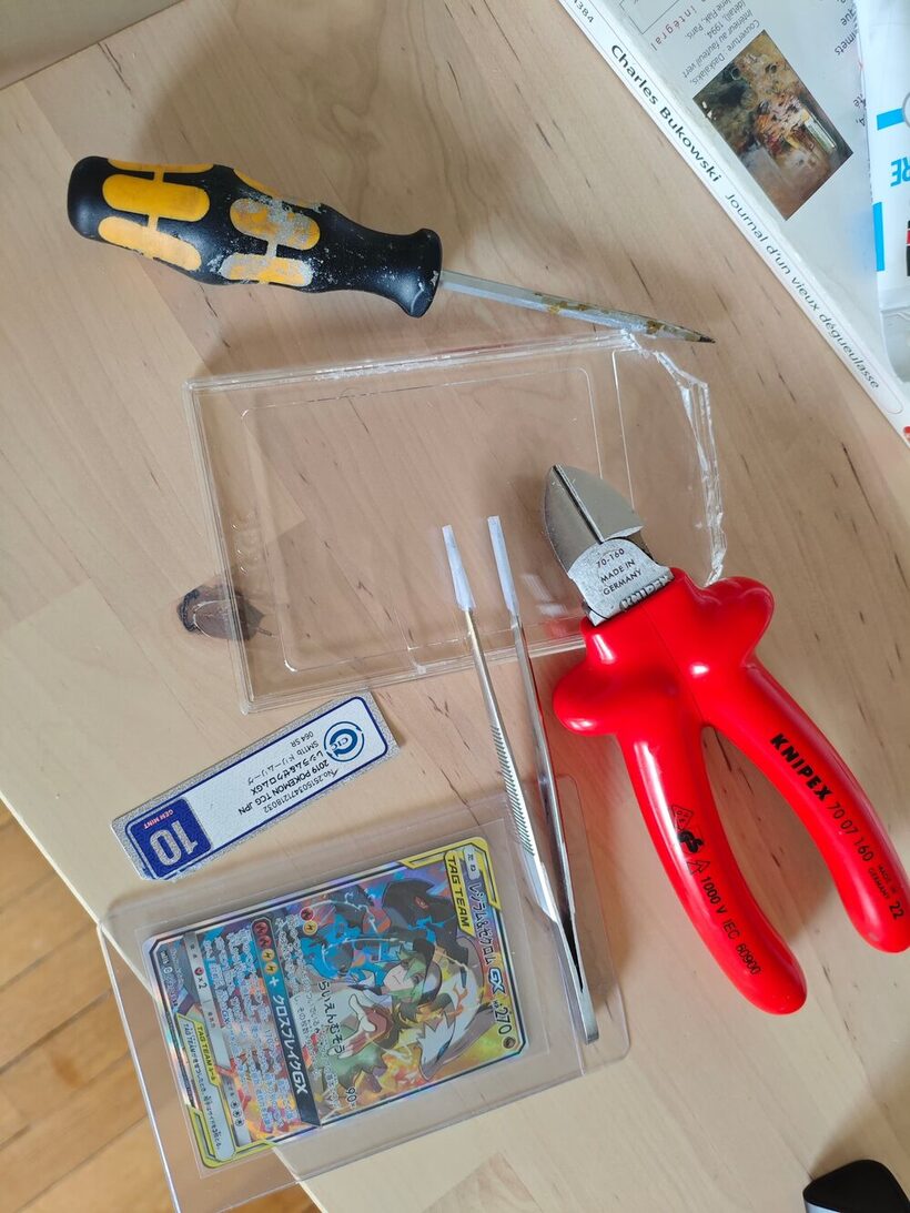 A CCIC slab cracked open, the brittle plastic shattered rather than flexed, with the card freed from the holder